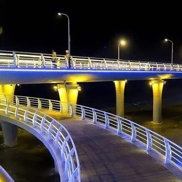 Pedestrian bridge and walkway outlined with white and blue lighting at night